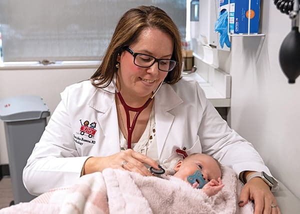 Riley doctor listening to the heart of a baby with a stethoscope. 